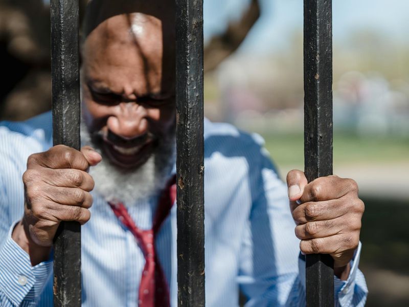 Close-up of a man's hands gripping a pull-up bar, showing determination.