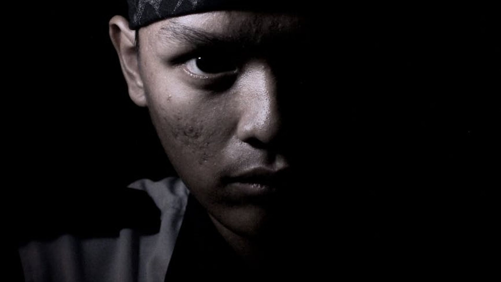 Silhouette of a man in a powerful stance against a minimal background.